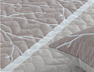 Colcha Jacquard con relleno fino Cancún y fundas de cojín color 01 Gris o 02 Beige